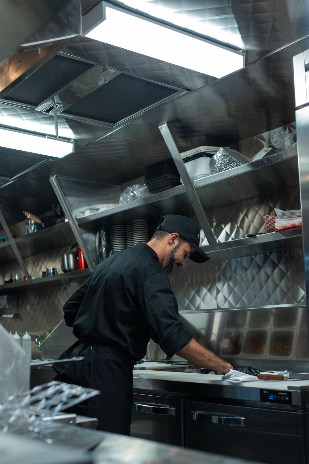 Cook working at the counter inside a food truck kitchen.